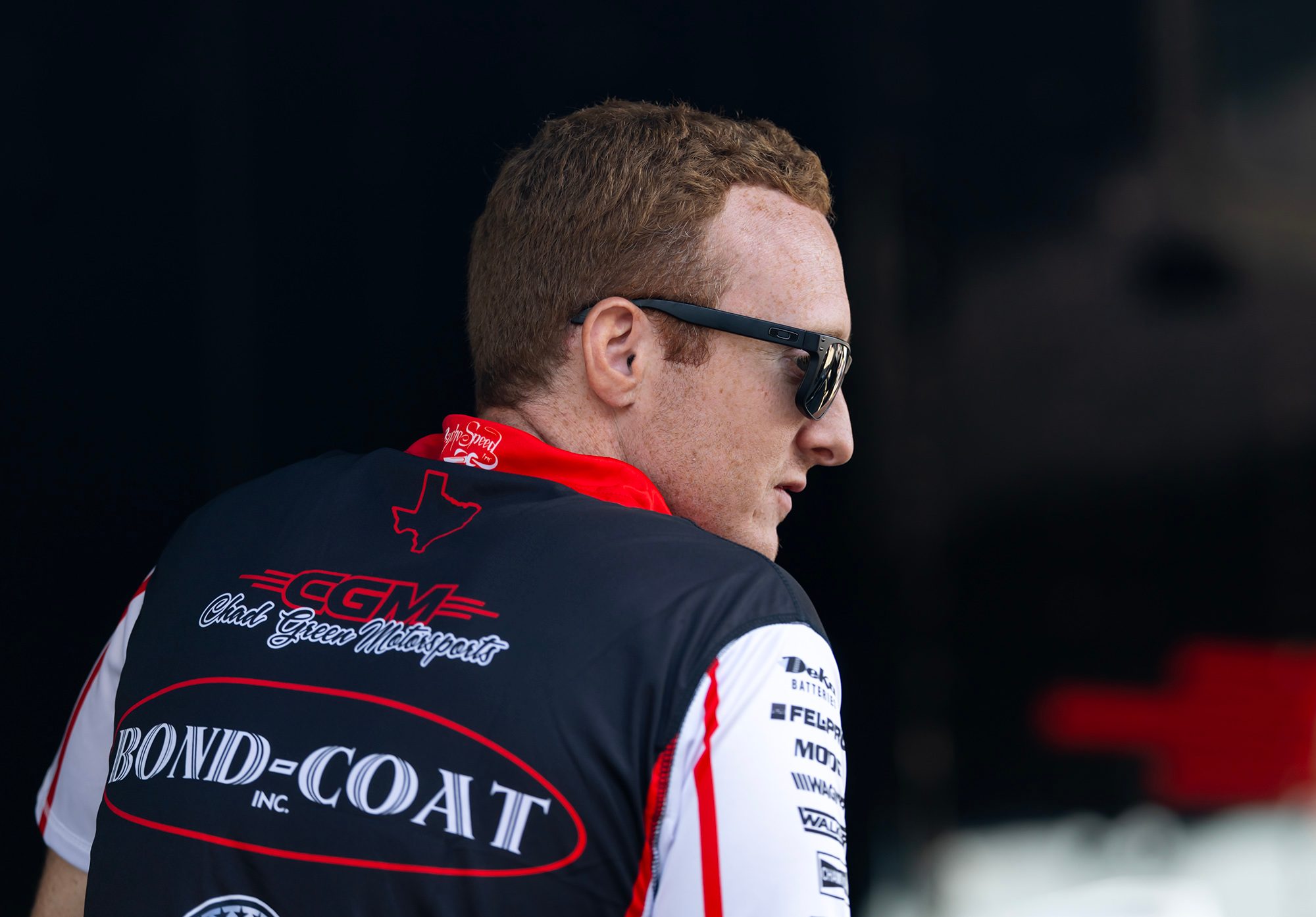 Hunter Green in the team shirt, looking over his shoulder in the pits