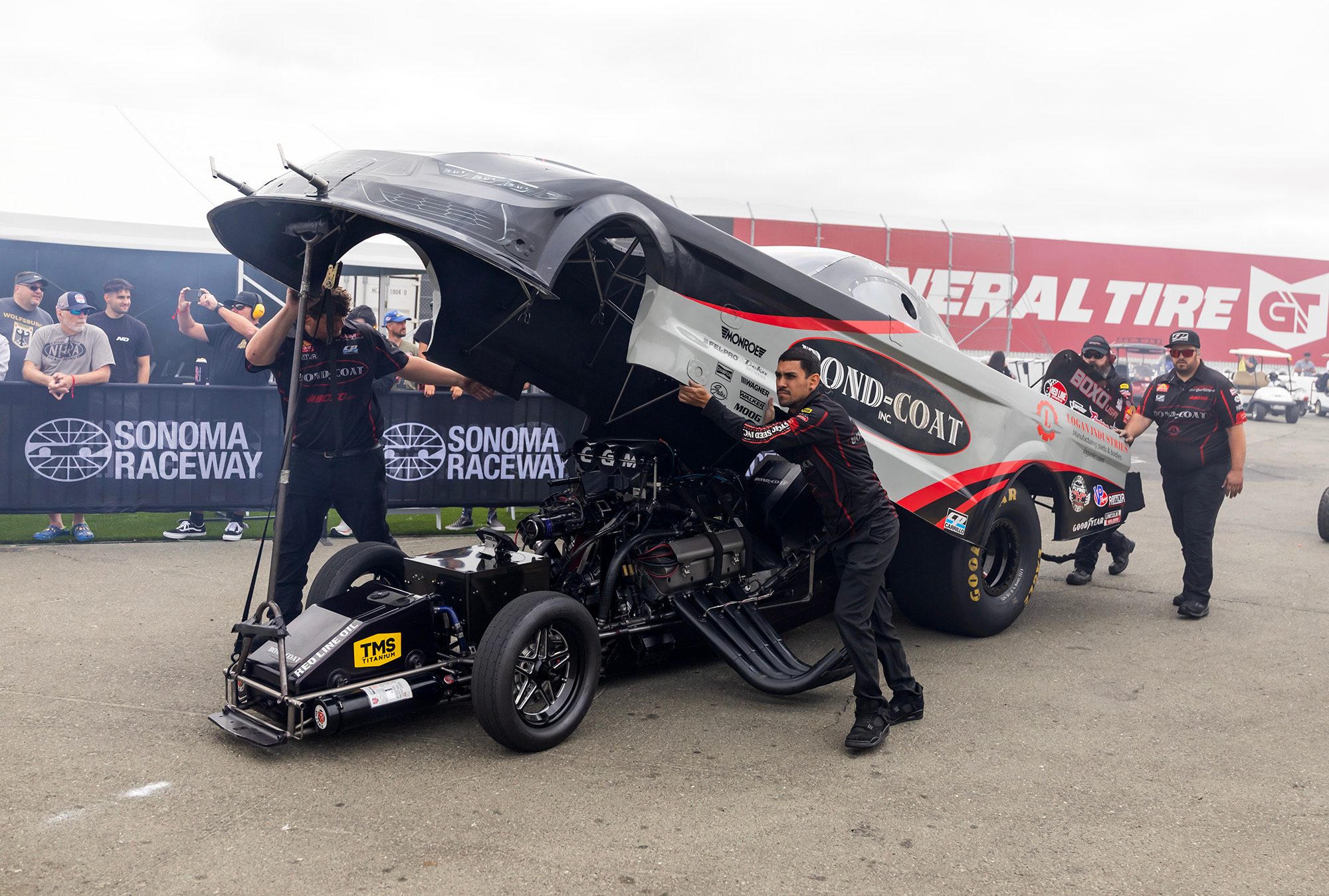 The crew rolls the car, body up, through the Sonoma pits
