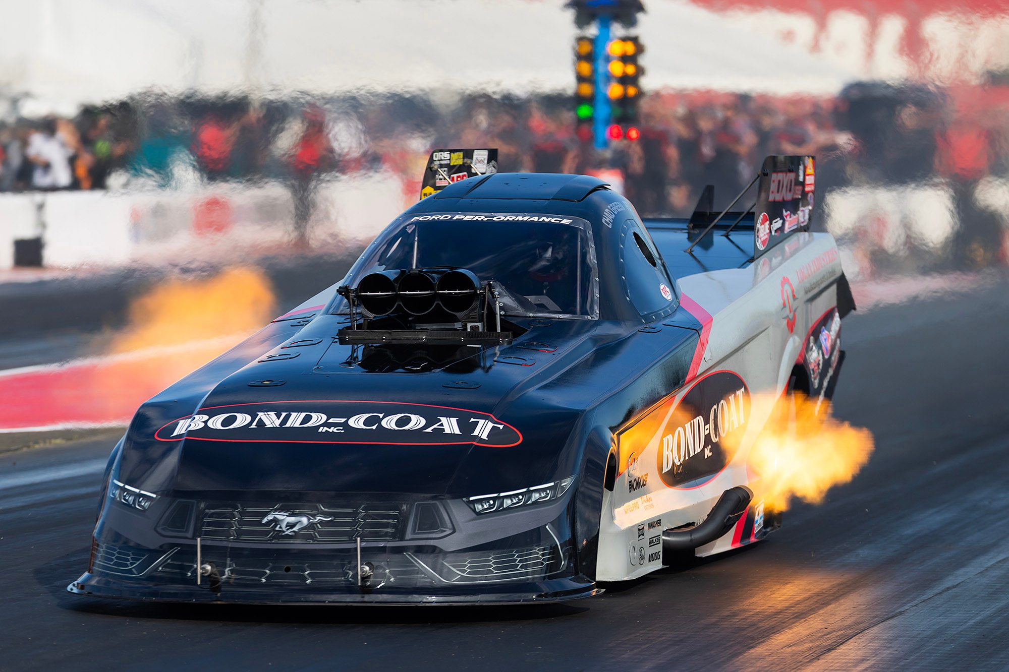 Flames and tire smoke as the Bond-Coat Funny Car launches