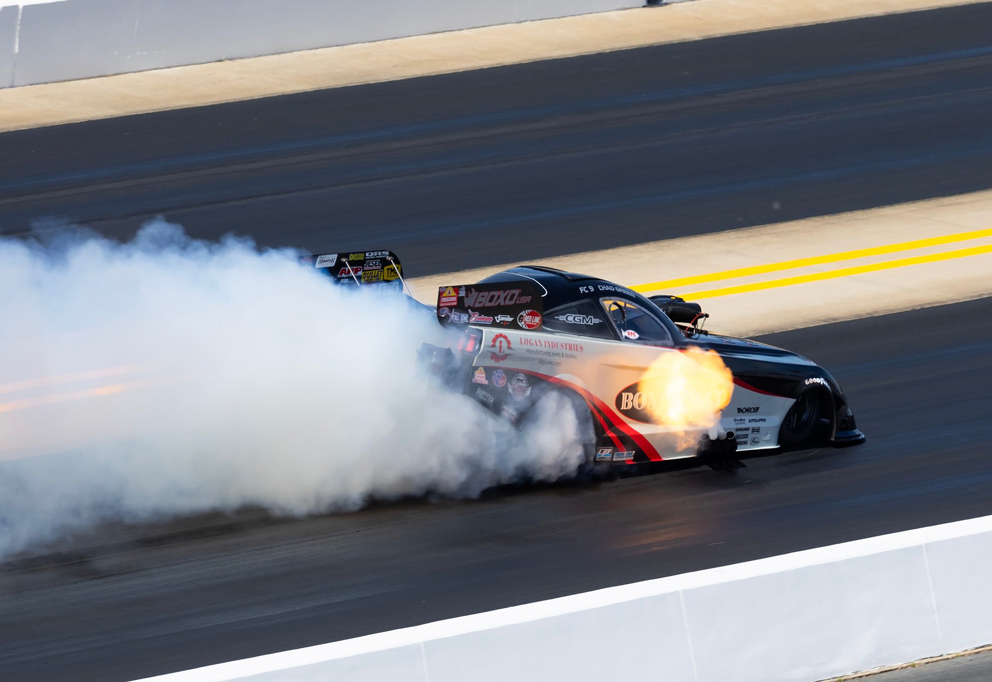 Burnout: the Bond-Coat Funny Car disappears into tire smoke with header flames lit