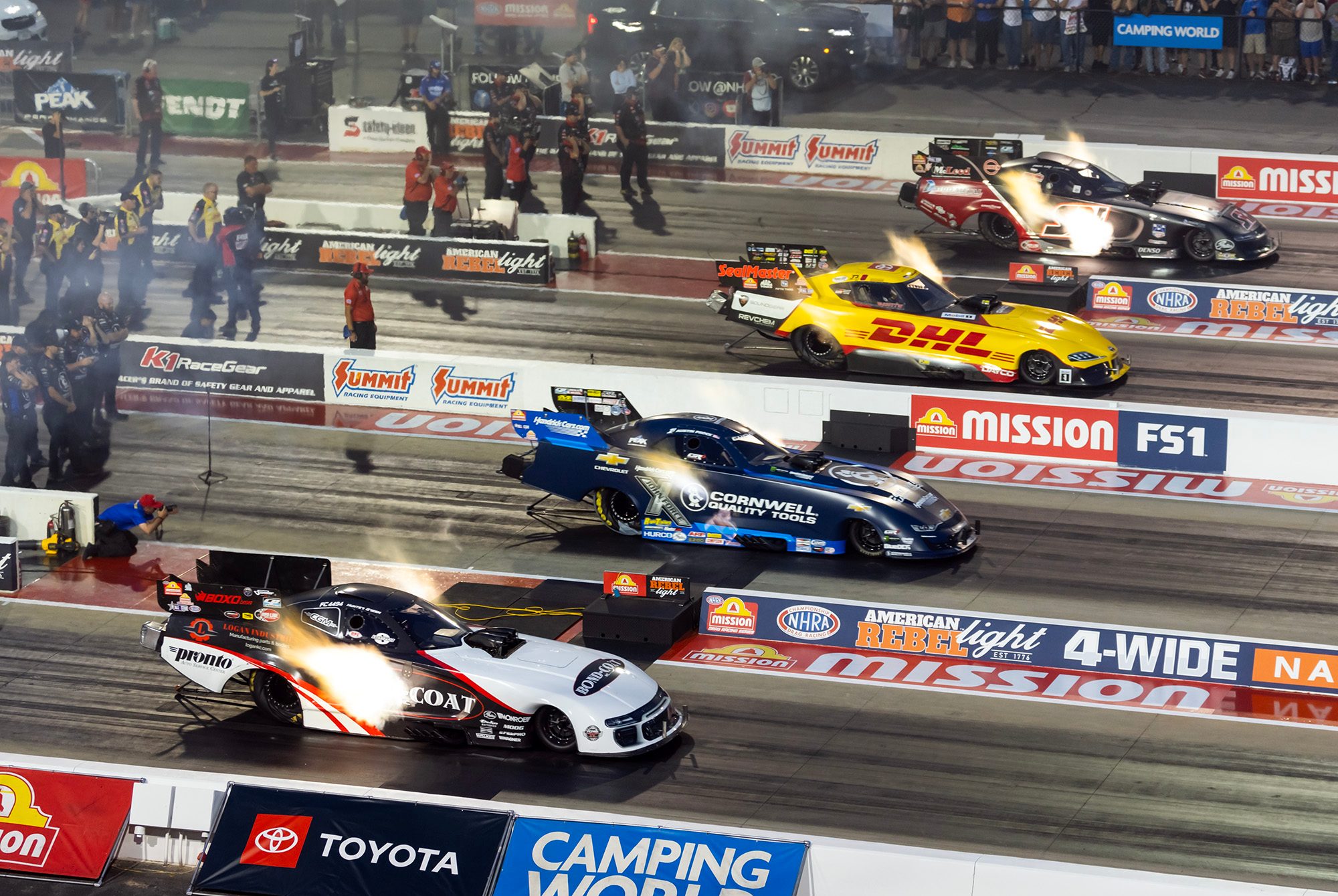 Four lanes launch together, the Bond-Coat Funny Car on the near wall at a four-wide national