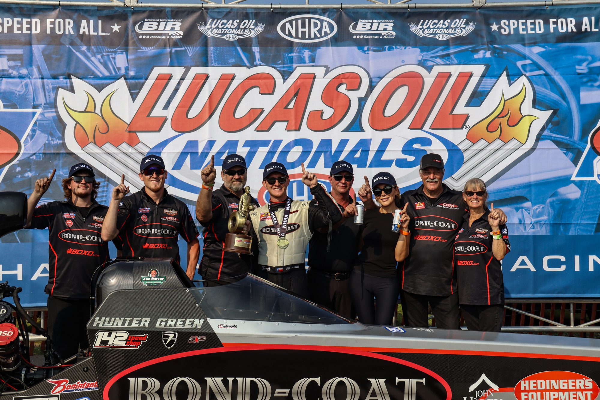 Team photo at the Lucas Oil Nationals winner's backdrop, Hunter Green's dragster in front